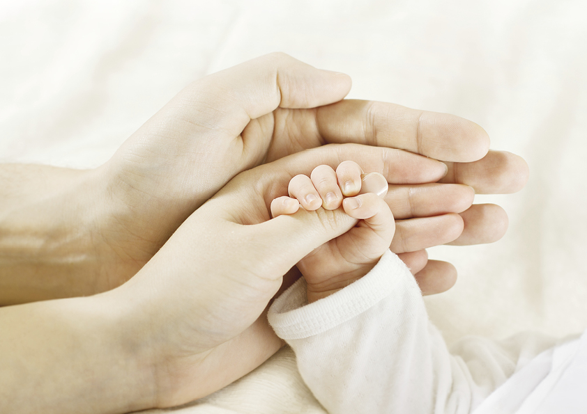 תמונת ידיים מחזיקה תינוק למאמר טובים השניים מן האחד